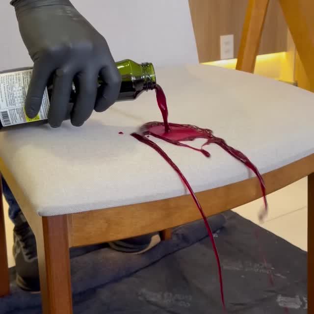 Técnico da Doutor Sofá, com máscara, óculos, luvas e proteção nos pés, a limpar as almofadas de um sofá claro.